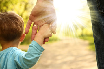  parent holds the hand of a small child