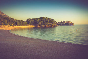Wall Mural - View in the Adriatic sea and beach at sunset. Milocer Park. Sveti Stefan. Coast Budva Riviera. Montenegro.Vintage effect.