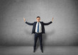© gearstd - Young businessman stands pushing invisible walls with his hands on a concrete background