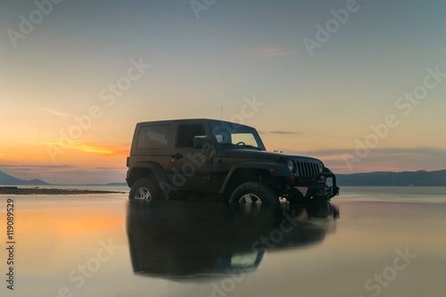 Fotomural Car 4x4 in the mud against a beautiful sunset.