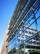 Spiegelnde Glasfassade mit Photovoltaikanlage eines modernen Verwaltungsgebäude vor blauem Himmel im Sonnenschein am alten Hafen in Münster in Westfalen im Münsterland