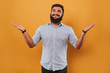 © sergiubirca - portrait of handsome smiling man isolated on yellow studio background posing to the camera and making funny faces, comparing with hands