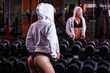 © Fotokvadrat - sexy young blonde girl in hoodie with perfect body posing with barbell in gym