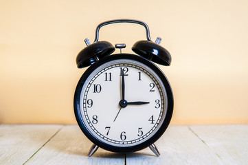 Vintage background with retro alarm clock 3pm am on wooden table