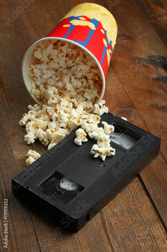 Fényképezés Popcorn near a videotape on wooden background