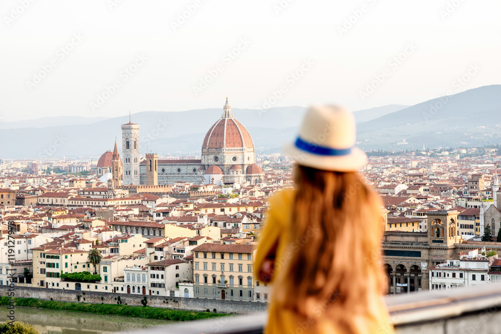Young female tourist looking on the old town of Florence from Michelangelo square in the morning in Italy. Back focus - obrazy, fototapety, plakaty 