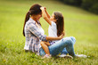 © BalanceFormCreative - Mother sitting with her daughter and playing around the park on beautiful morning.