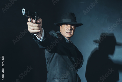 Fotografia  Vintage film noir 1940s gangster shooting with gun.