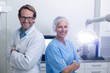 © WavebreakMediaMicro - Smiling dentist and dental assistant standing with arms crossed