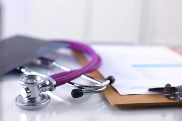 Medical stethoscope lying on a computer keyboard, cup of coffee