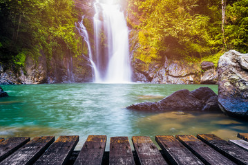 Waterfall in deep forest and wood pier for background. Can be used for display or montage your products.