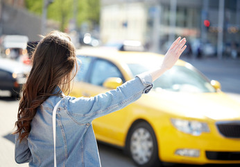 Wall Mural - young woman or girl catching taxi on city street