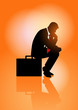 © rudall30 - Pensive businessman sitting on his briefcase