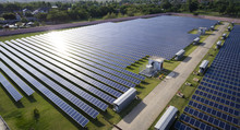 Aerial View Of Solar Farm Under Sunlight Raying On Panels