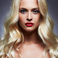 luxury beautiful young woman with healthy curl blond hair. long wavy hair girl with make-up