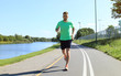 © ty - Running sport man. Fit muscular young male runner sprinting at great speed outdoors on road.