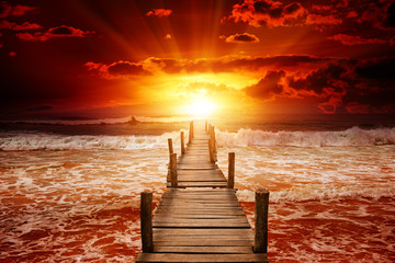 Wall Mural - Pier for boats into the sea. Bright sunrise over the ocean.
