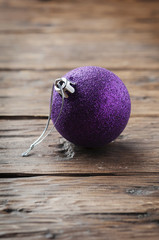 Wall Mural - Christmas card with purple ball on the wooden table