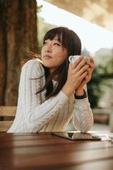 Chinese woman having coffee at outdoor cafe