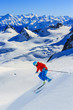 Male skier skiing in fresh snow off ski slope on a sunny winter day at high mountain in French Alps. Freeski in powder snow.