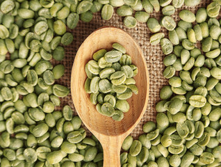 Poster - Coffee grains with wooden spoon on sackcloth, closeup