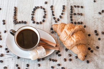 Wall Mural - Cup of coffee with grains, croissant, turkish delight and cinnamon sticks on wooden background. title i love coffee.