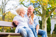 © Kzenon - Senior couple sitting on part bench in fall