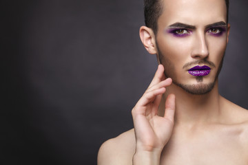 Gay. Pretty sensual fashion man with art makeup and beard.