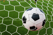 © ohmega1982 - Soccer football in Goal net with green grass field.