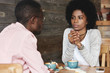 © wayhome.studio  - Close up portrait of African American friends at cafe having serious conversation, fashionable hipster woman with Afro hairstyle looking at her boyfriend with puzzled and thoughtful face expression