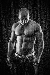 Wall Mural - very muscular handsome athletic man in the rain