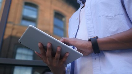 browsing online on tablet, standing young black male designer