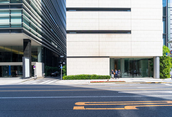 modern office buildings in tokyo from urban road with sunbeam