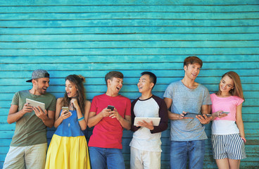 Wall Mural - Young people with gadgets on wooden planks background