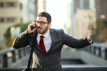angry furious businessman on cell phone call yelling and screaming in city