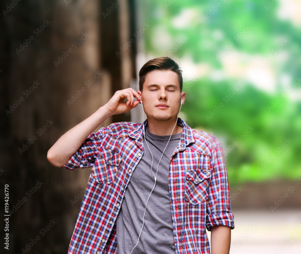 Handsome man listening music on street