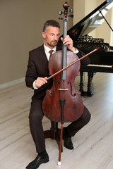 Wall Mural - Man playing cello in room