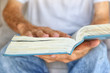 Old man holding and reading Bible