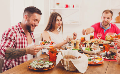 Wall Mural - Group of happy people at festive table dinner party