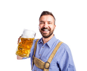 Man in traditional bavarian clothes drinking beer