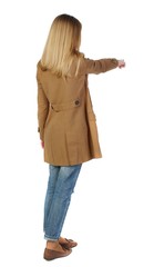 Wall Mural - Back view of pointing young women in parka. blonde in a brown cloak, points a finger forward.