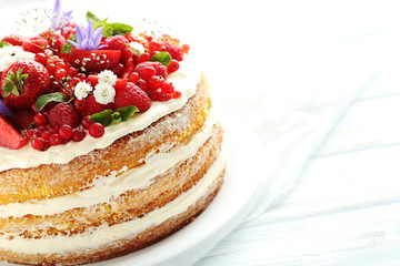 Wall Mural - Delicious biscuit cake with berries on blue wooden table