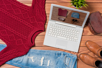 Wall Mural - Laptop and autumn clothes on wooden table. Online shopping concept