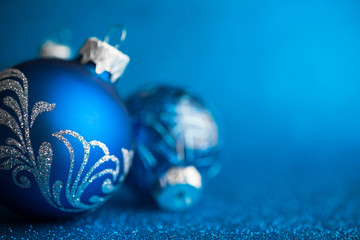 Wall Mural - blue xmas ornaments on dark blue glitter background with space for text. merry christmas card. winte