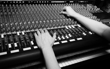 Sticker - hands of sound engineer working on recording studio mixer. bw filter