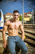 © theartofphoto - Portrait of young shirtless man with sexy body posing on train railway while looking down
