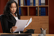 © DragonImages - Portrait of concentrated Asian business lady analyzing document