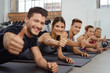 © contrastwerkstatt - gruppe im fitness-studio zeigt daumen hoch