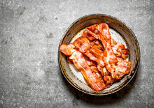 Fried Bacon In A Frying Pan. On Stone Background.