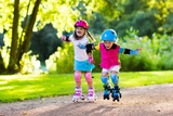 Kids roller skating in summer park
